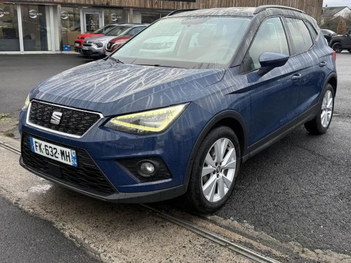 SEAT Arona bleu foncé mis en scène dans un hall en béton brut - photo d'origine