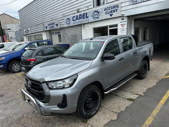 Toyota Hilux gris métallisé mis en scène dans un décor de dunes - photo d'origine